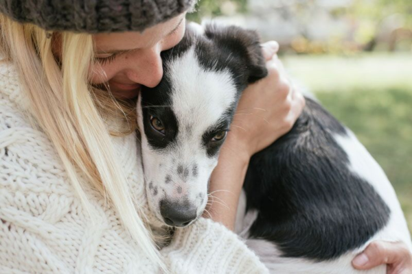 woman hugging a spotted puppy