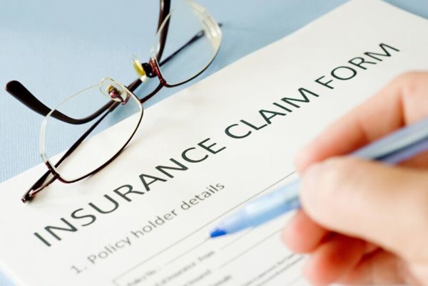 person filling out insurance claim forms