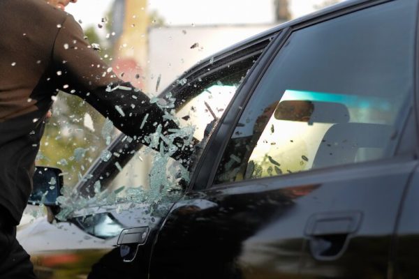 criminal breaking car window