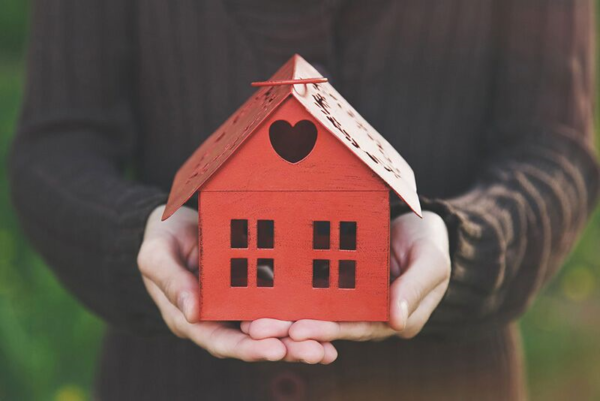 red toy home in hands