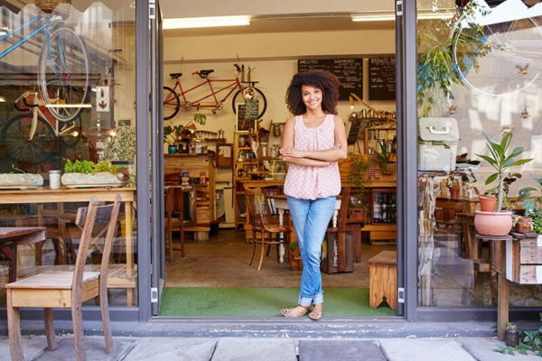 small business owner standing in front of her shop